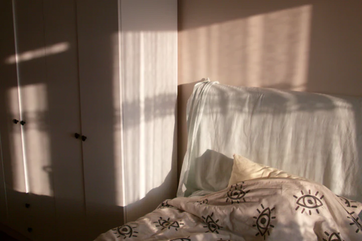Morning sunlight falling across an unmade bed.