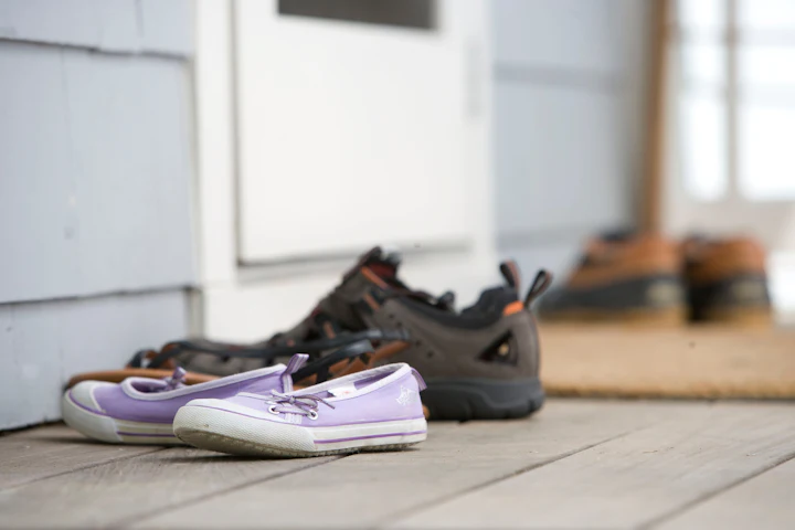 A pair of shoes resting on the ground next to a door.